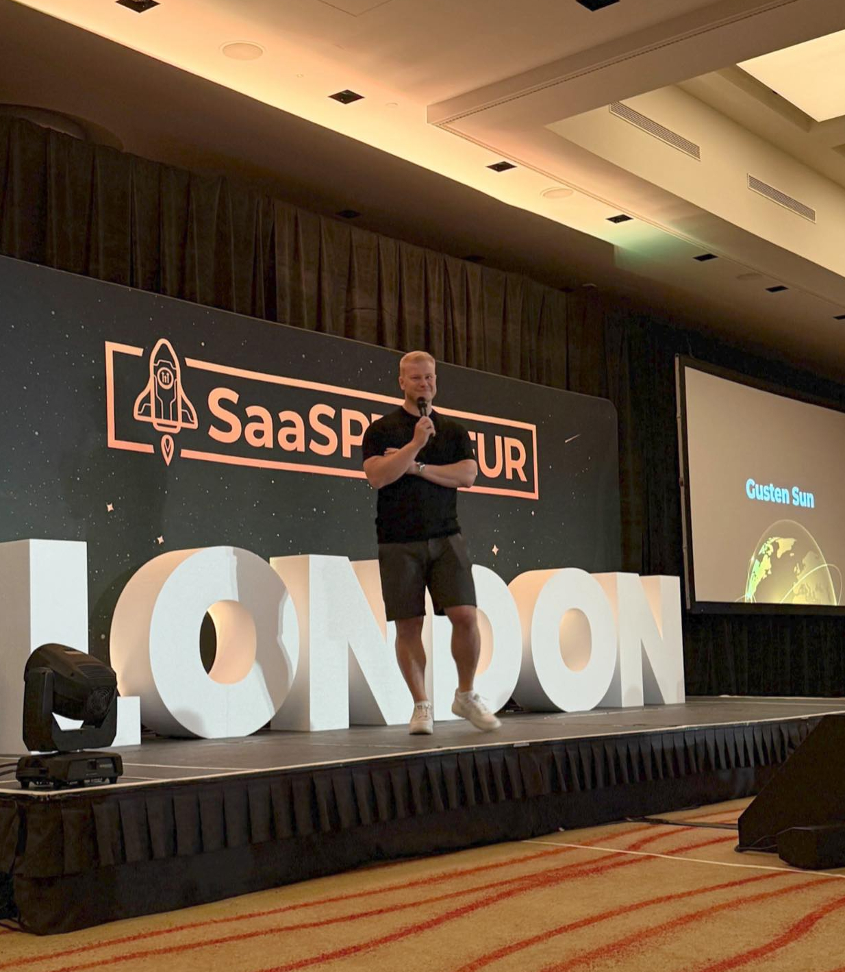 Gusten Sun speaking on stage in London